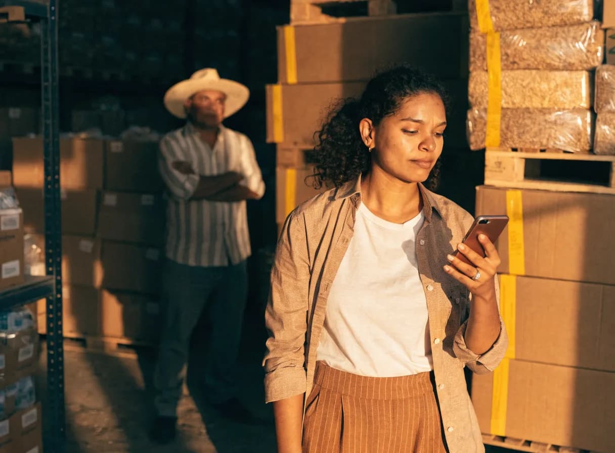 Exportadora revisando en su teléfono que el cobro de su exportación entró a la cuenta