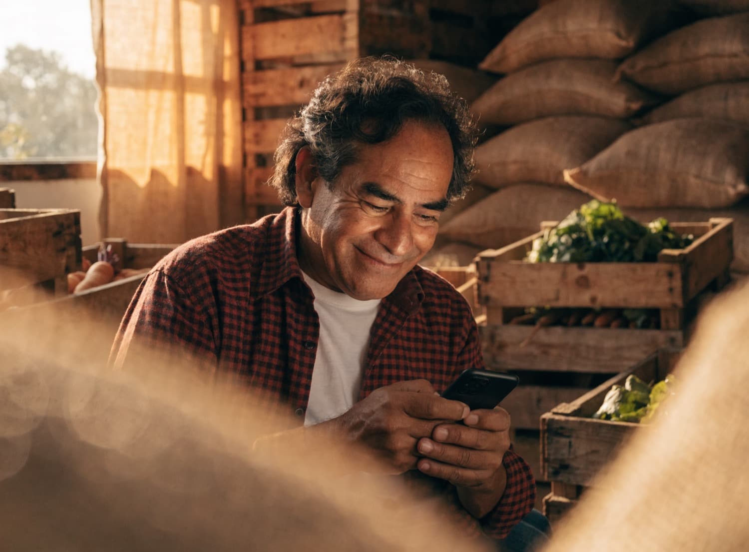 Empresario de alimentos revisa en su teléfono el pago de su exportación que entró a su cuenta de siempre, en su bodega.